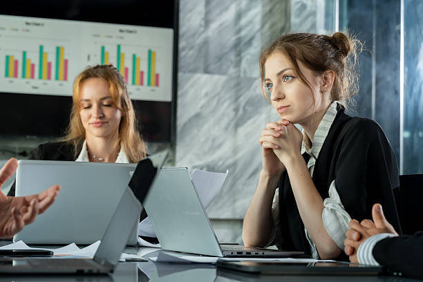 istock Young caucasian female professional thinking during business discussion, laptop and documents on table, teamwork with multiracial colleagues in office, planning strategy and collaboration 2232946032