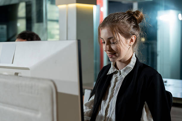 istock Caucasian female employee smiling while working on computer at office desk showing positive attitude concentration and enjoyment in professional workplace during routine business operation 2232946063