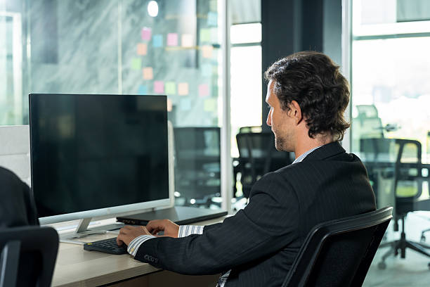istock Caucasian male employee working alone on desktop computer in office environment focusing on corporate task analysis and business productivity showing individual contribution to business operation 2232946065