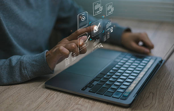 istock Close-up man hand selecting digital document icons on virtual intelligent screen above laptop symbolizing online document management paperless workflow approval systems modern offices 2232953111