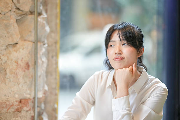 istock A woman is sitting at a table with her hands on her lap 2232953378