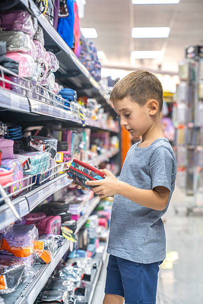 istock Elementary School Child standing in bookstore and looking for pencil case. Back To School Shopping Concept. Shopping for school. Little boy trying to decide which pencil case to buy. 2232953773