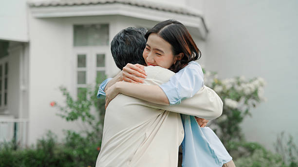 istock Mother and daughter embracing together at front yard 2232955664
