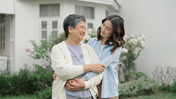 istock Mother and daughter embracing together at front yard 2232956431