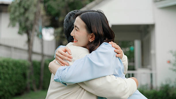 istock Mother and daughter embracing together at front yard 2232956459