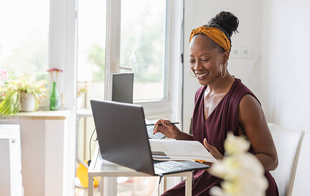 istock Smiling woman using laptop while sitting at desk in office 2232960625