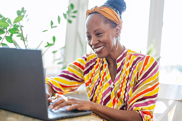 istock Smiling woman using laptop while sitting at desk in office 2232960671