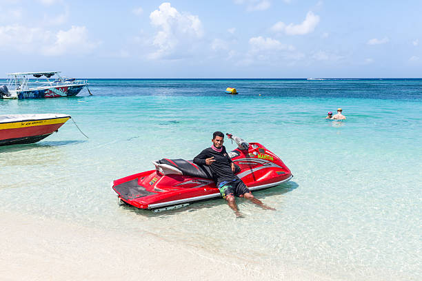 West Bay Beach, Roatan Island, Honduras - April 16, 2024: A jet skier waits for tourists on West Bay Beach in Roatan, Honduras.