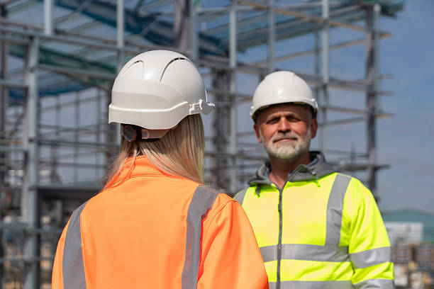 istock Two construction workers in bright safety jackets engage in conversation on a building site 2232962753