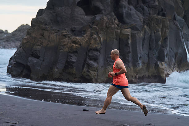 istock Man running on the black sand beach 2232962843