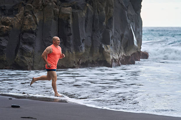 istock Man running on the black sand beach 2232962888