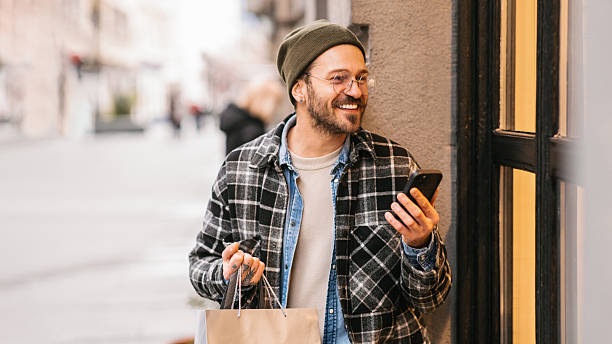 Man with shopping bags using smartphone