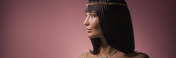 istock Cleopatra Look With Golden Headpiece and Dramatic Profile On Pink Backdrop 2232963974
