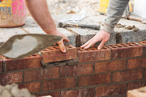 istock Close-up of Skilled bricklayer laying bricks with trowel on construction site 2232964025