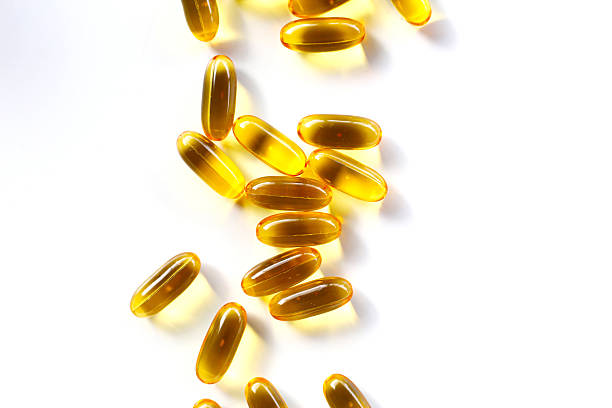 istock Golden fish oil capsules on white background. 2232966957