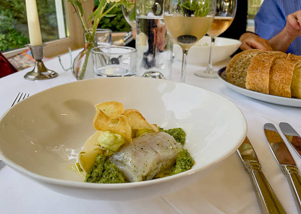 istock A neatly plated dish on a white plate, served on a table with white linen in a fine dining restaurant. The menu features refined dishes with colorful garnishes, carefully presented. 2232967221