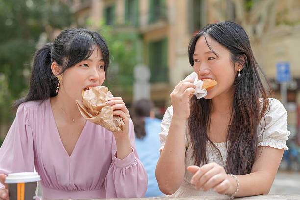 istock Two women eating food at a table 2232968080