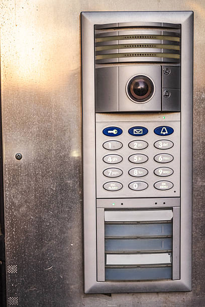 istock Modern metal intercom with keypad and camera mounted on building entrance 2232968901