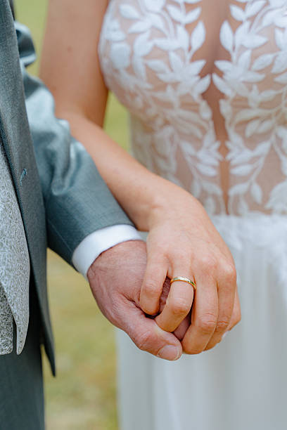 istock Bride and Groom Holding Hands in Wedding Attire 2232977099