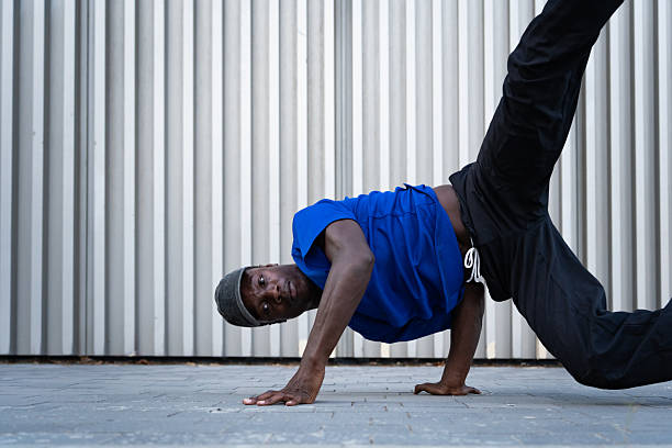 istock Young man breakdancing on a vibrant city street, showcasing impressive skills while executing a dynamic freeze move under the sun 2232978316