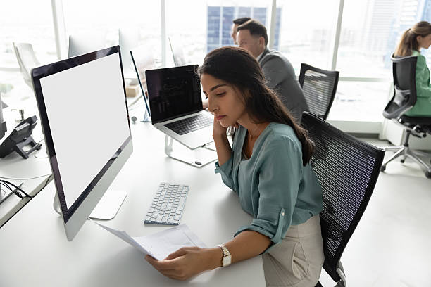 istock Young Latina woman deeply focused on reviewing important documents 2232980573