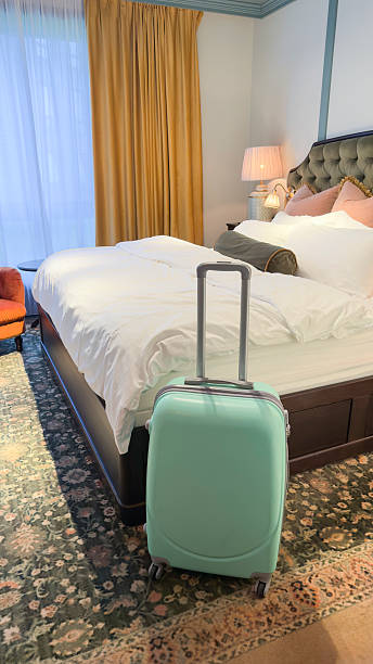 istock Green suitcase stands in hotel room ready for vacation 2232982880