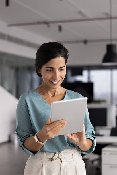 istock Positive businesslady working on digital tablet in contemporary workspace 2232982988