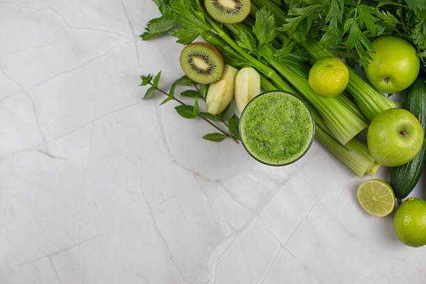 istock Fresh green smoothie with fruits and vegetables on marble table top view with copy space 2232983456