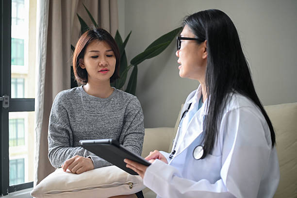 istock Caring Female Physician Examining Patient in Clinic 2232987580
