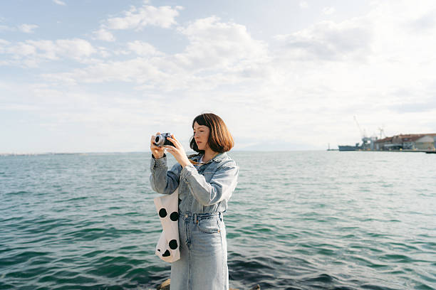 Photo of a young woman photographing with her digital camera, while on a city break vacation