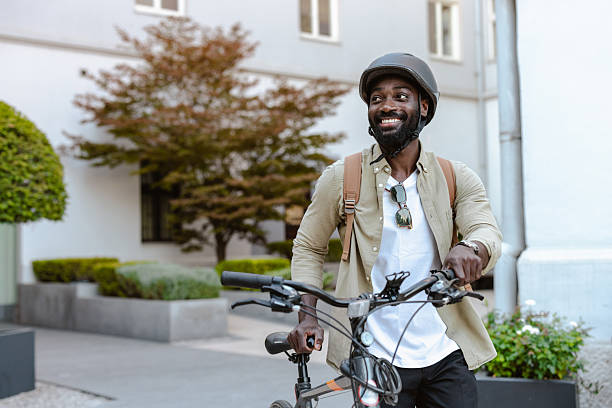 istock Smiling man walking with bicycle outdoors near modern building on sunny day 2232991755