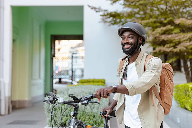 istock Smiling man walking with bicycle outdoors near modern building on sunny day 2232991854