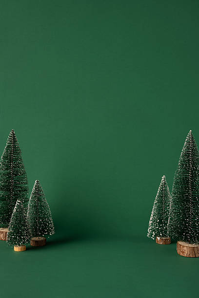 Miniature vertical Christmas tree decorations on a green background, perfect for festive-themed greeting cards. This scene conveys a cozy and merry holiday concept ideal for seasonal visuals and similar designs
