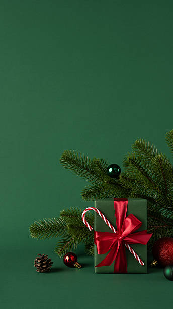 istock Festive vertical scene featuring a wrapped gift with a red bow and holiday ornaments 2232991967