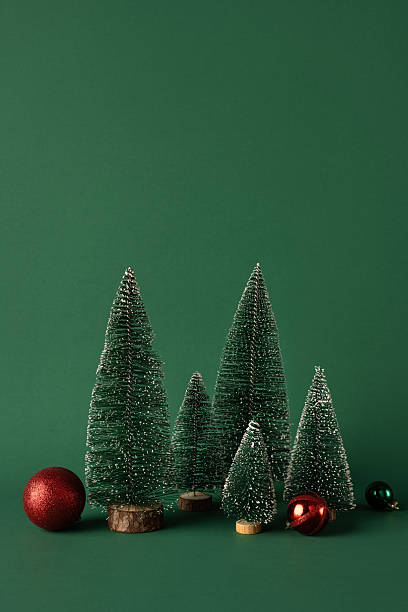 istock Green vertical miniature Christmas trees with sparkling decorations and red ornaments on a matching backdrop creating a magical holiday atmosphere perfect for seasonal greeting cards 2232991979