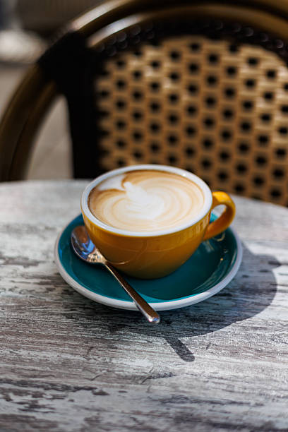 istock Cappuccino with latte art in yellow cup on cafe table 2232995006