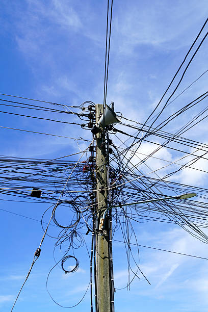 istock Messy Power Lines and Wires Against Clear Blue Sky Background 2232995068