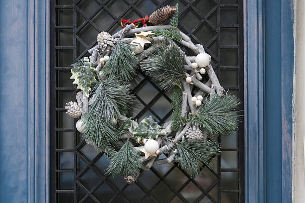 Christmas wreath with branches and silver balls on a glass door Entrance