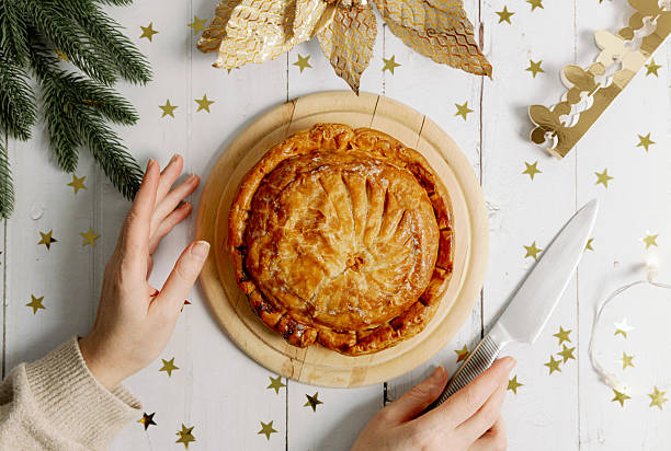 istock A woman's hands clasp a box with a royal galette and a crown on the table. 2233005499