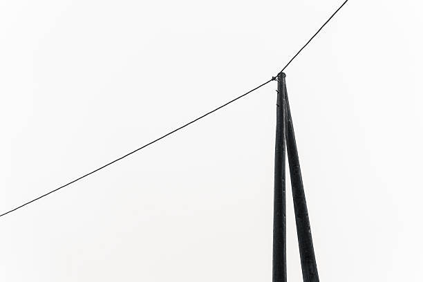 Minimalist black and white photograph of poles and wire