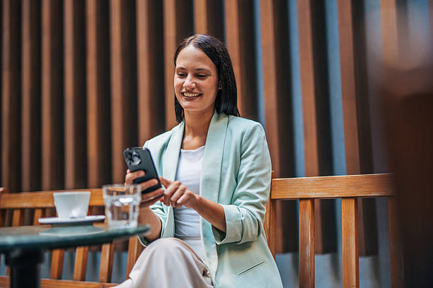 istock Businesswoman using smartphone at outdoor cafe during break 2233005887