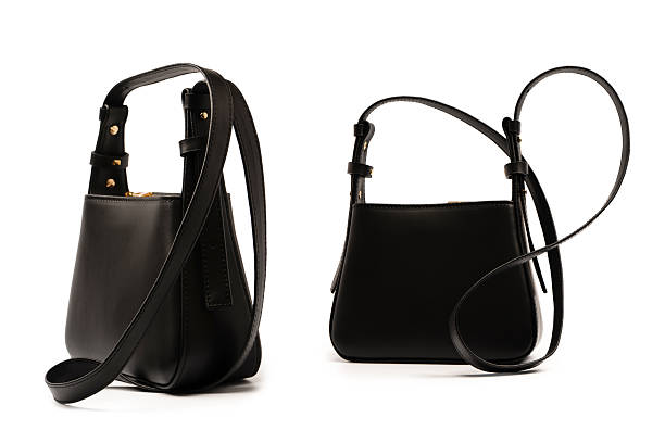 Black small leather cross body bag isolated on a white background.