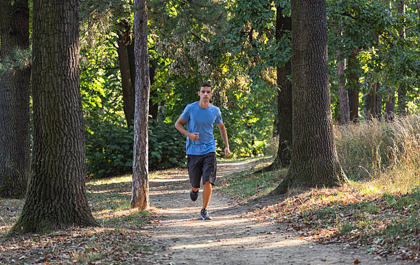 istock Young man running in the forest on a sunny day 2233016103