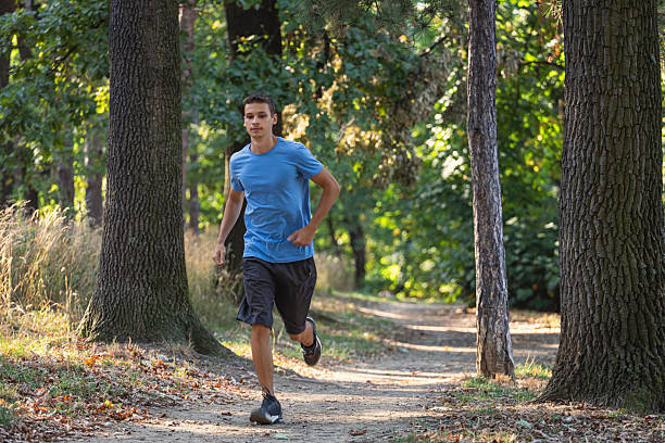 istock Young man running in the forest on a sunny day 2233016104