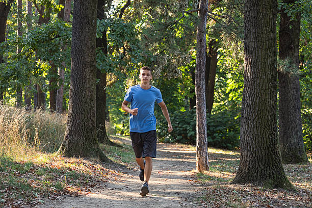 istock Young man running in the forest on a sunny day 2233016107
