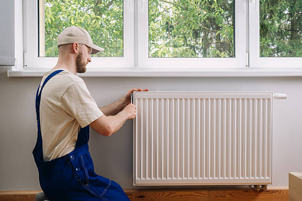 istock Man repairing a radiator for efficient home heating in a modern living space 2233016162