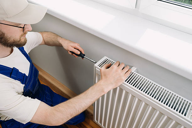 istock Home heating maintenance by a technician installing a radiator in a living space 2233016163
