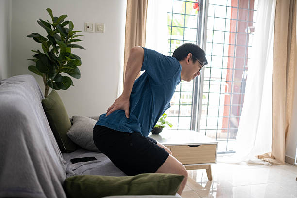 istock Early Morning Discomfort: Man Touching Sore Lower Back Indoors 2233016305