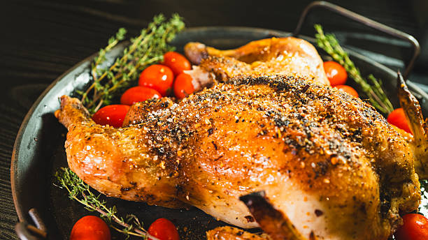 istock Whole roasted golden chicken with thyme and cherry tomatoes on board 2233016310