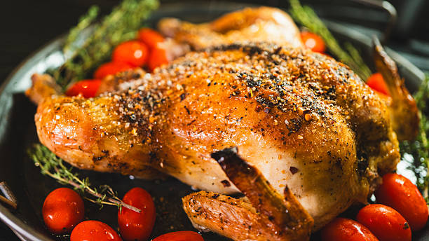 istock Whole roasted golden chicken with thyme and cherry tomatoes on board 2233016317
